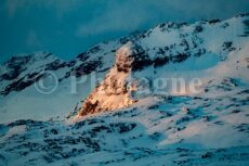 Paesaggio innevato e scogliera al sole nascente